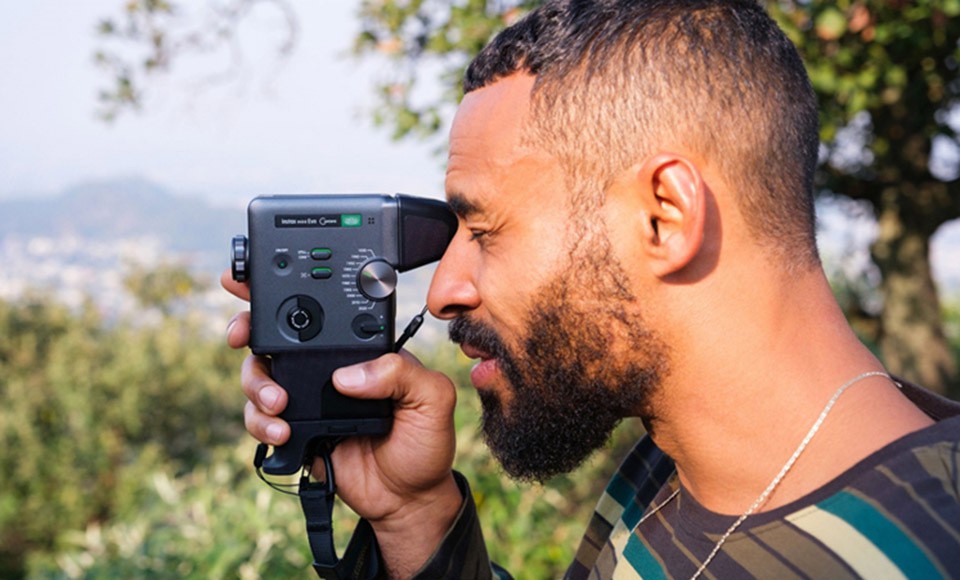 A photographer using the external viewfinder accessory to shoot with the mini Evo Cinema